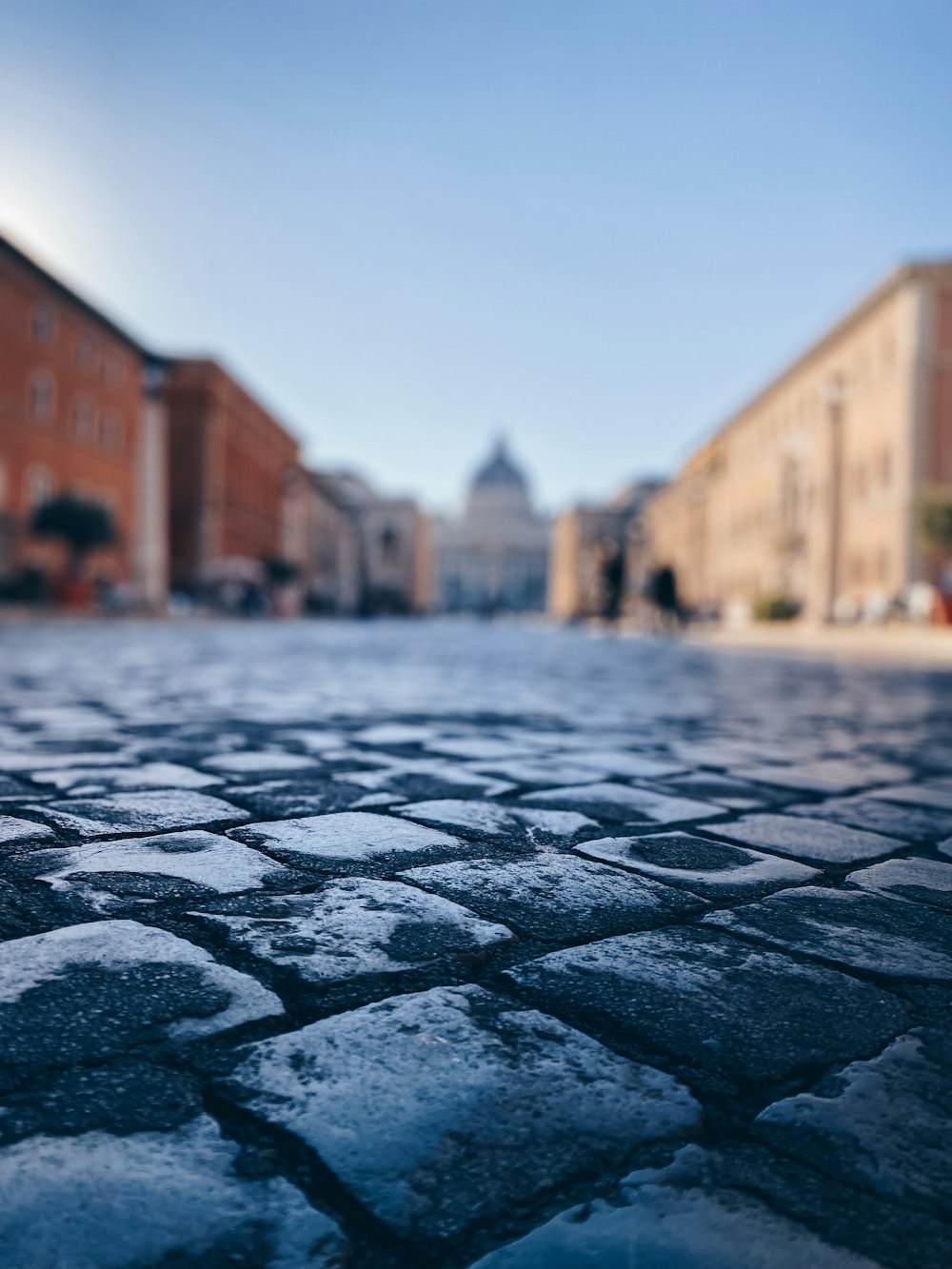 a cobblestone street with buildings in the background