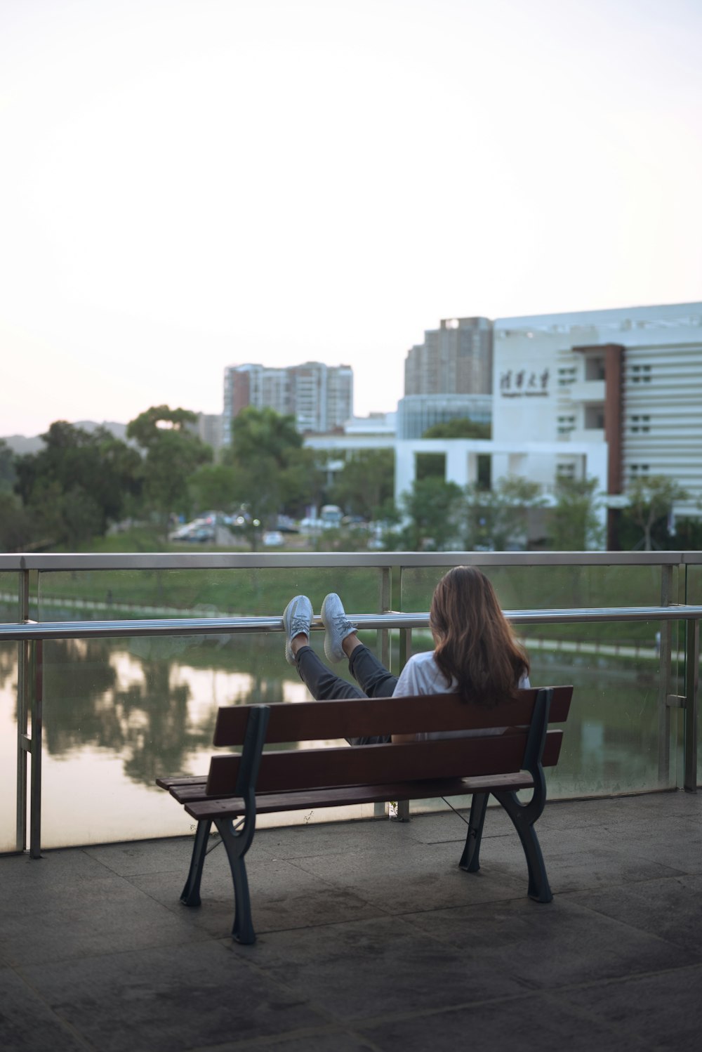 a woman sitting on a bench with her legs crossed