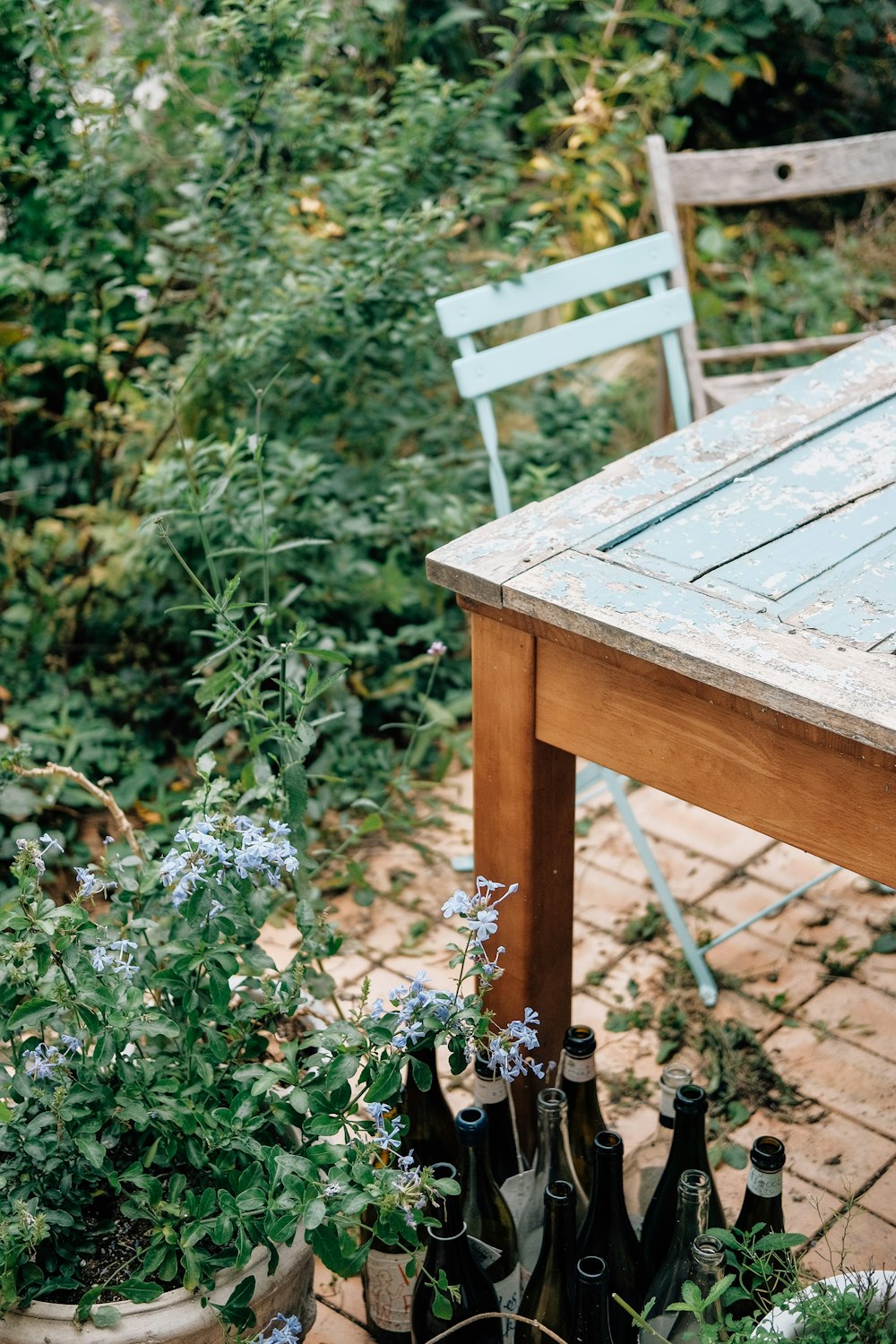 a wooden table sitting next to a bunch of bottles