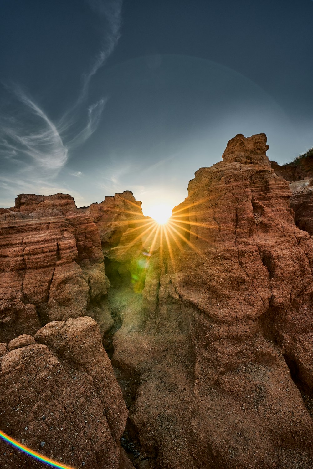 the sun is shining through the rocks in the desert