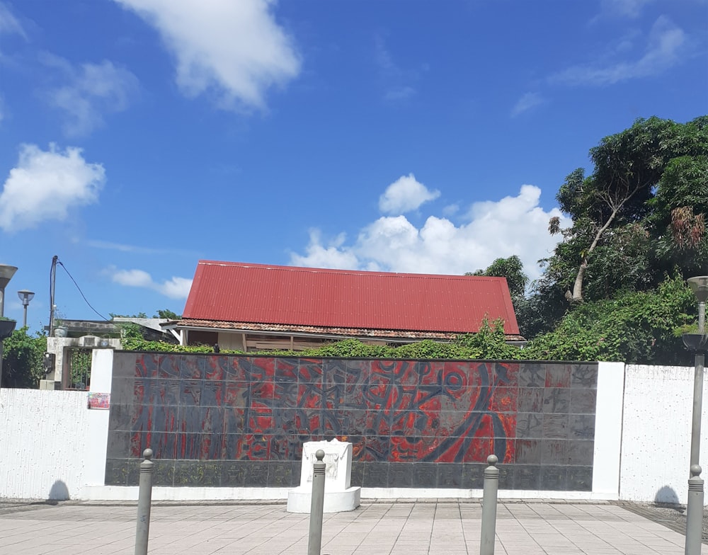 un edificio con un tetto rosso accanto a una recinzione