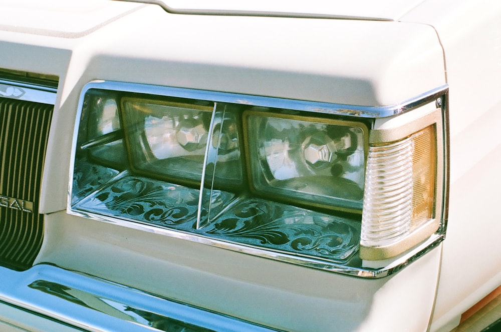 a close up of the headlights of a white car