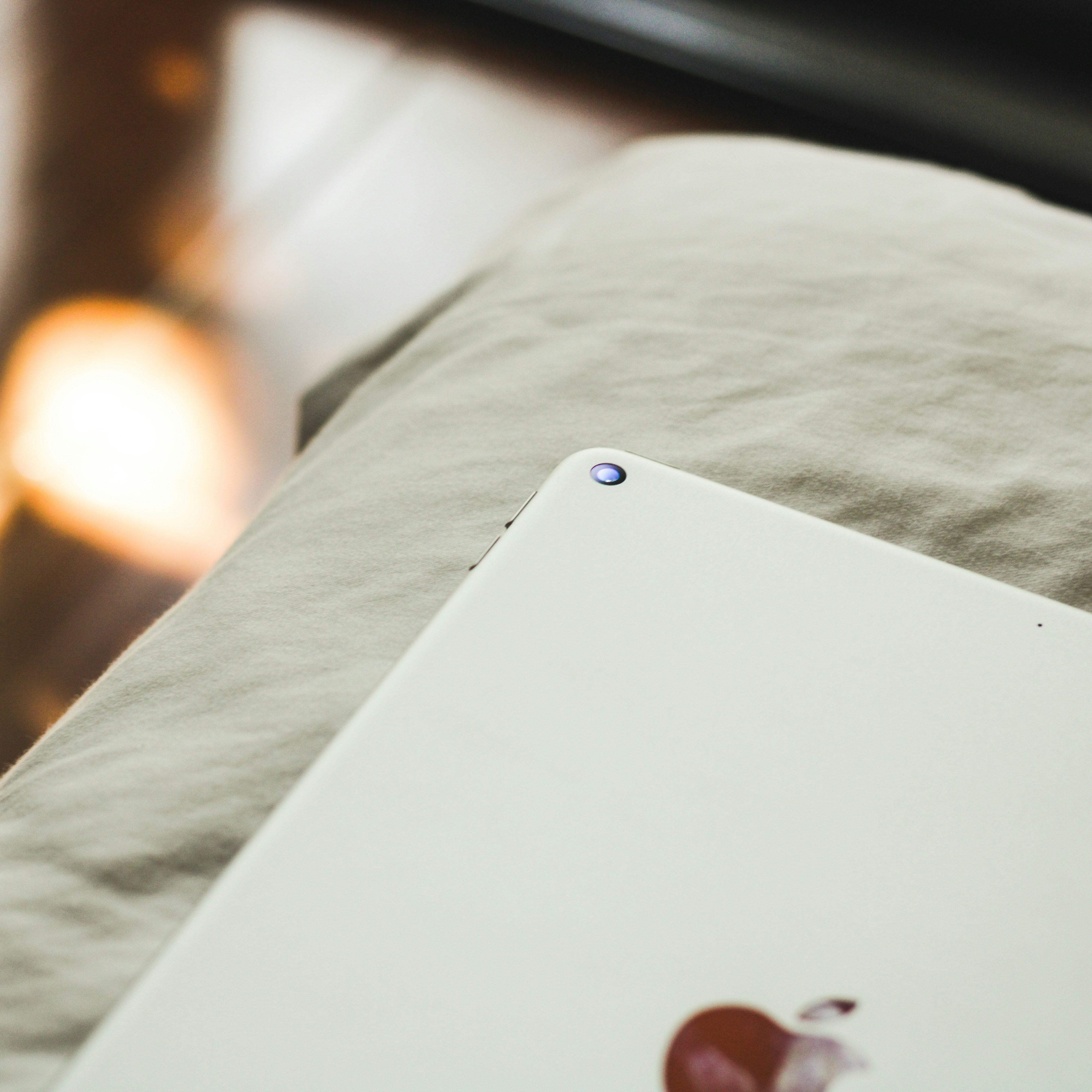 an apple laptop sitting on top of a bed
