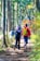 A group of travelers hiking through a lush green forest with sunlight filtering through trees.