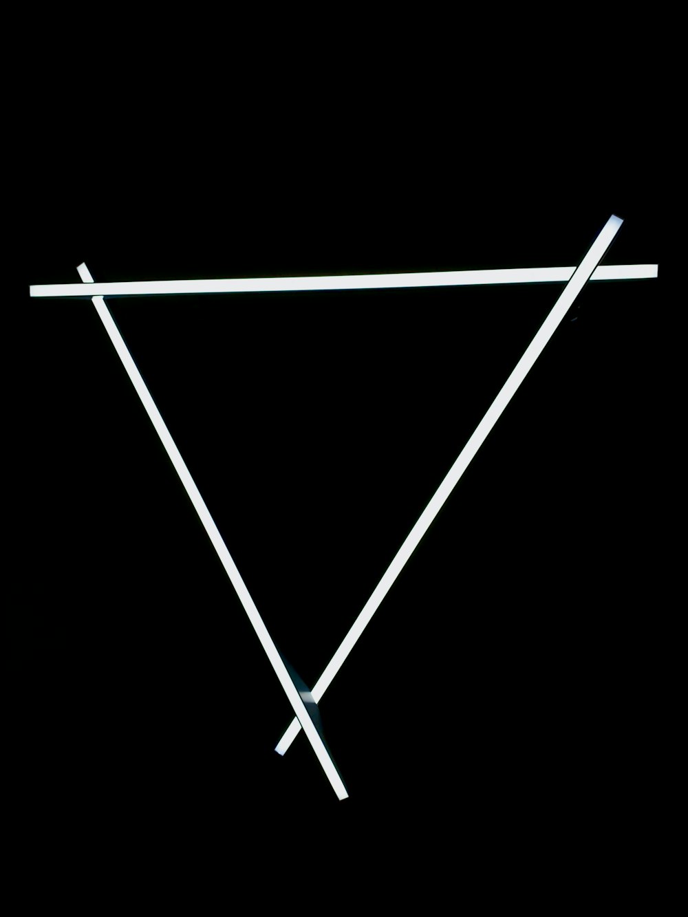 a black background with a white triangle and two white sticks