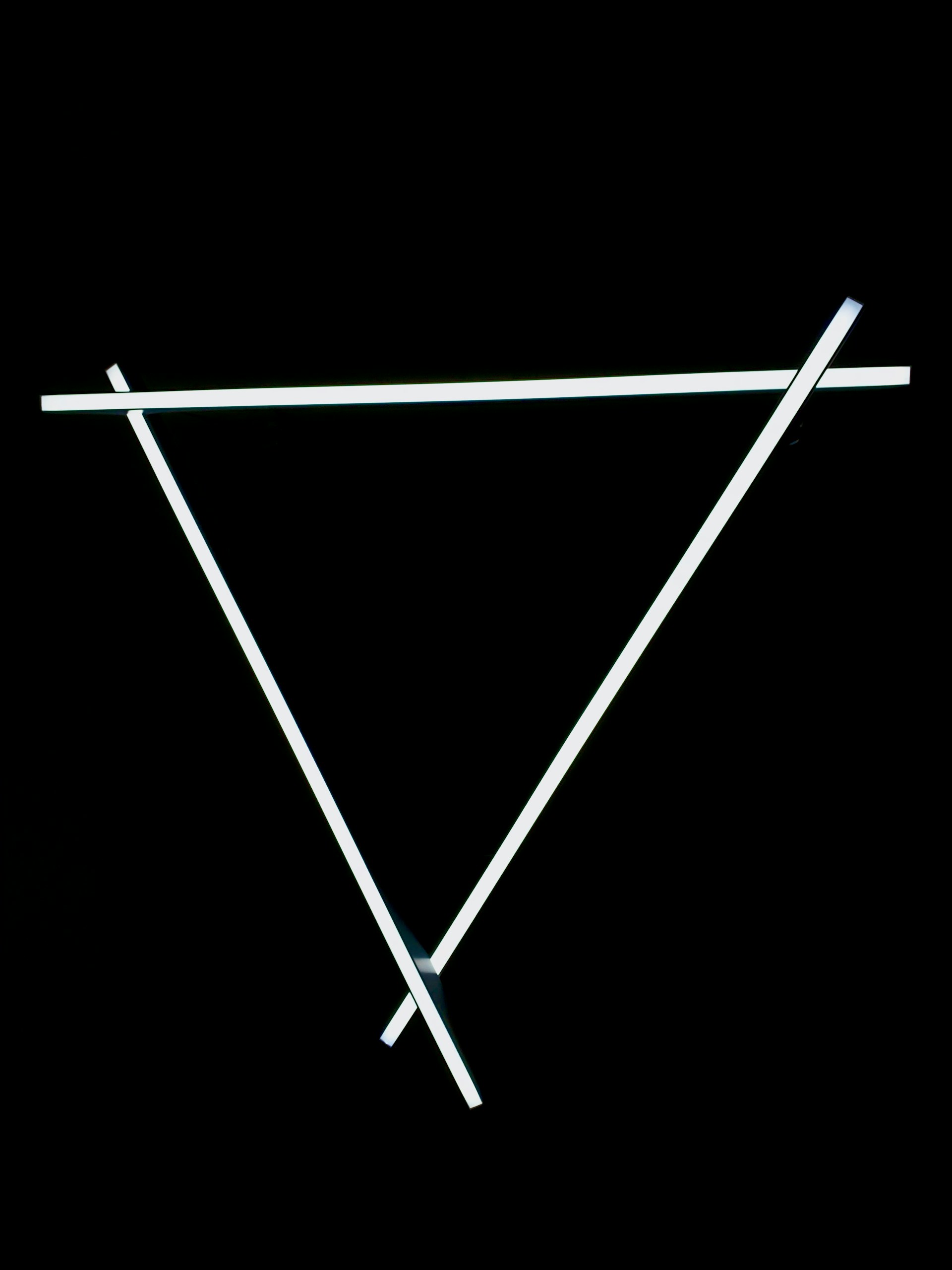 a black background with a white triangle and two white sticks