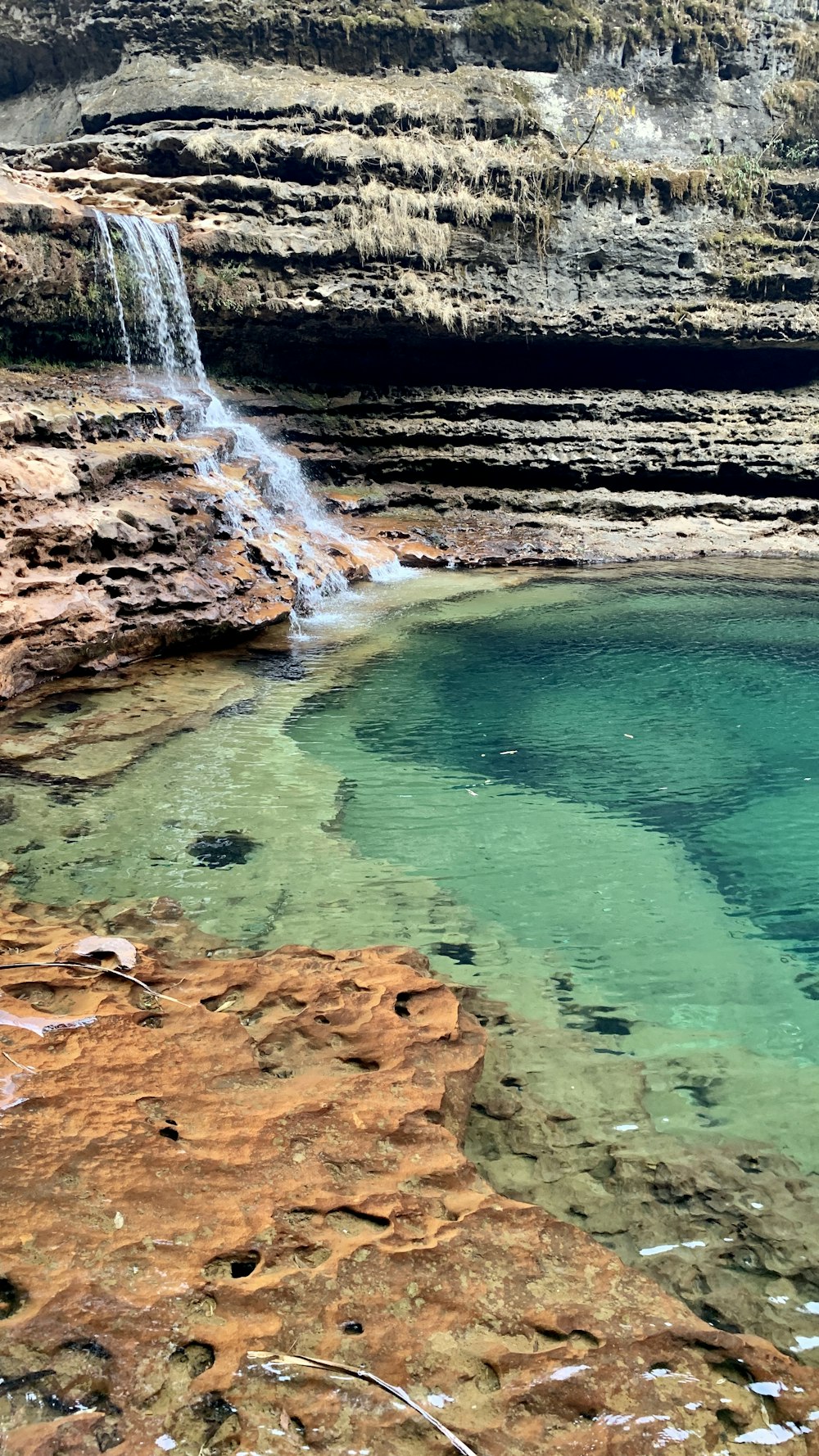 a small waterfall in the middle of a body of water