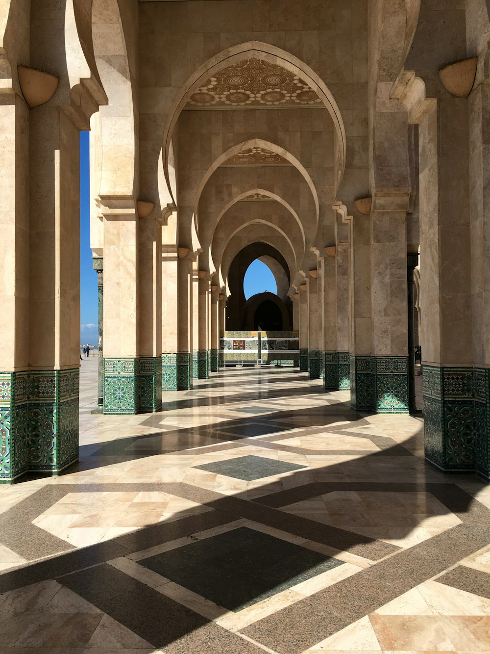 a long hallway with arches and tiled floors