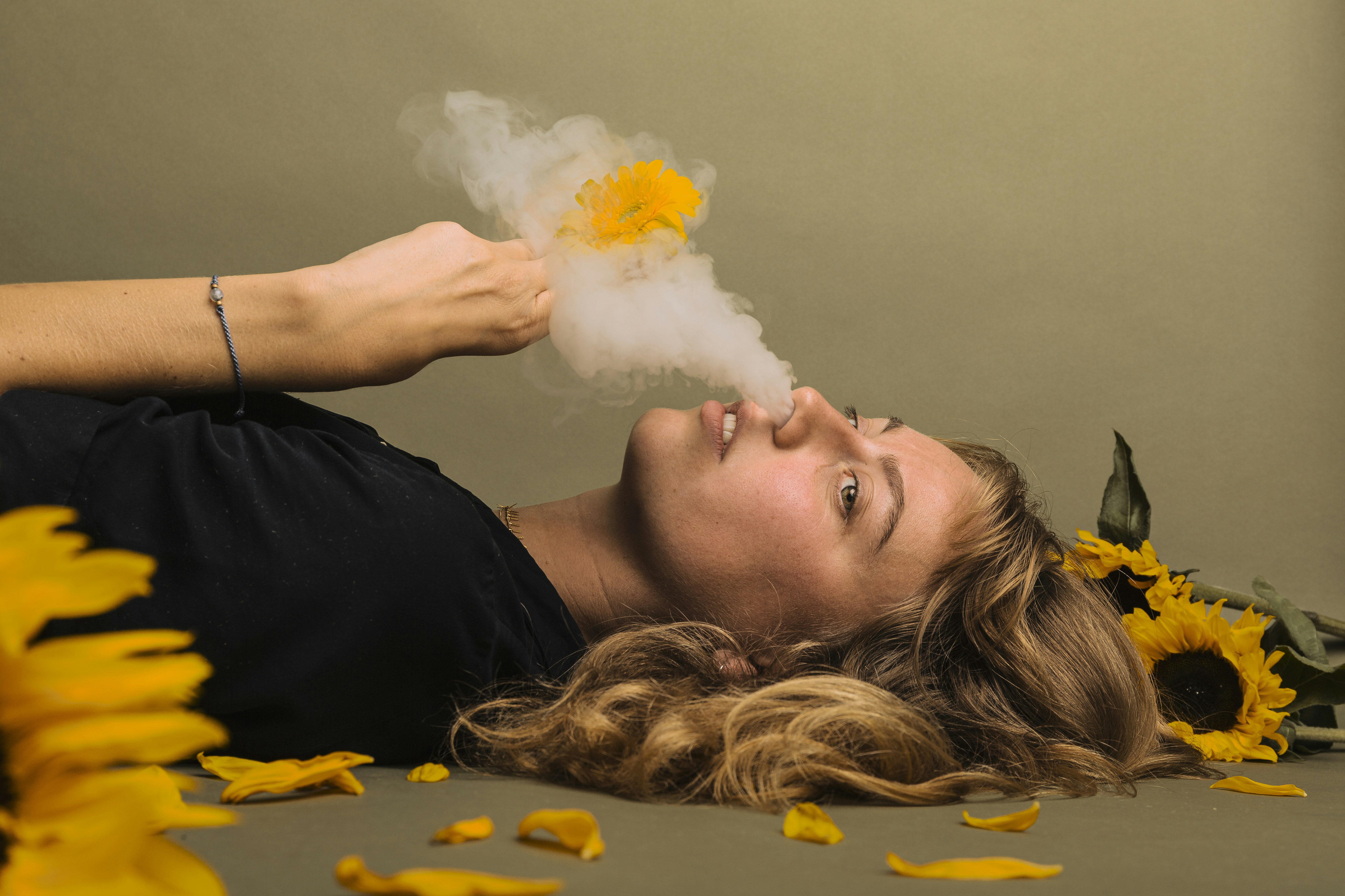 a woman laying on the ground with a cloud of smoke coming out of her mouth