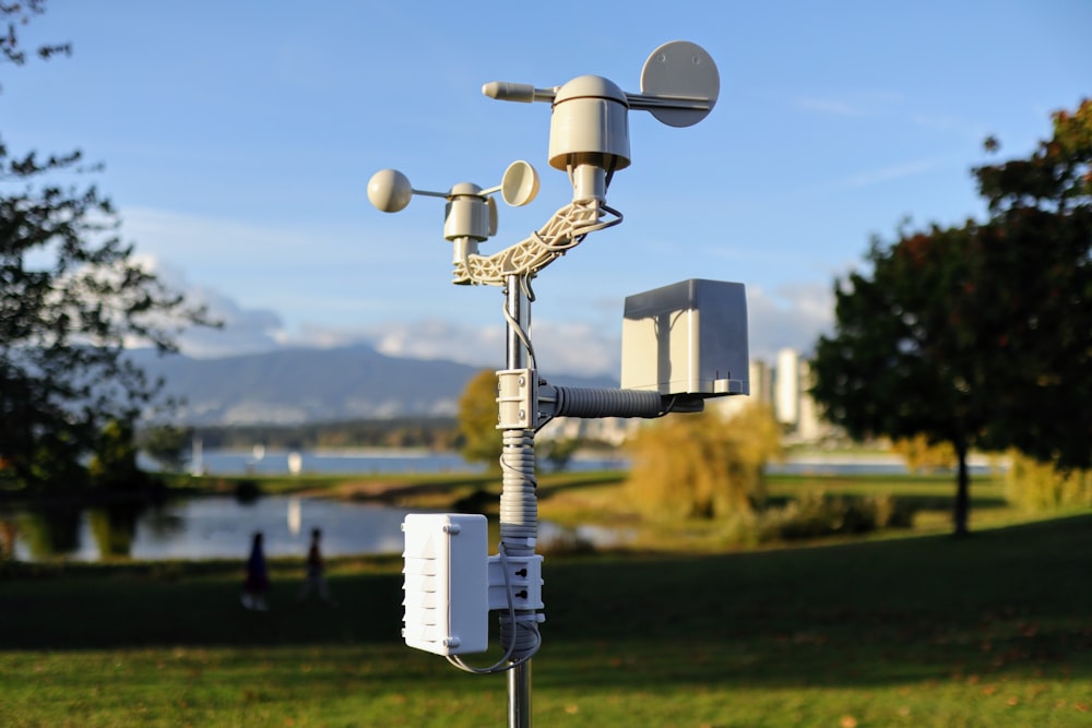 a cell phone tower in a park with a lake in the background