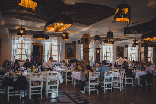 a group of people sitting at tables in a restaurant | Restaurants for Large Groups & Parties