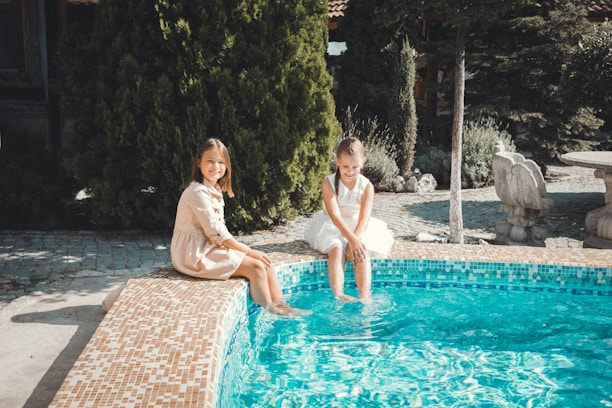 Family relaxing by a clean backyard pool after dependable pool service in Central Texas.