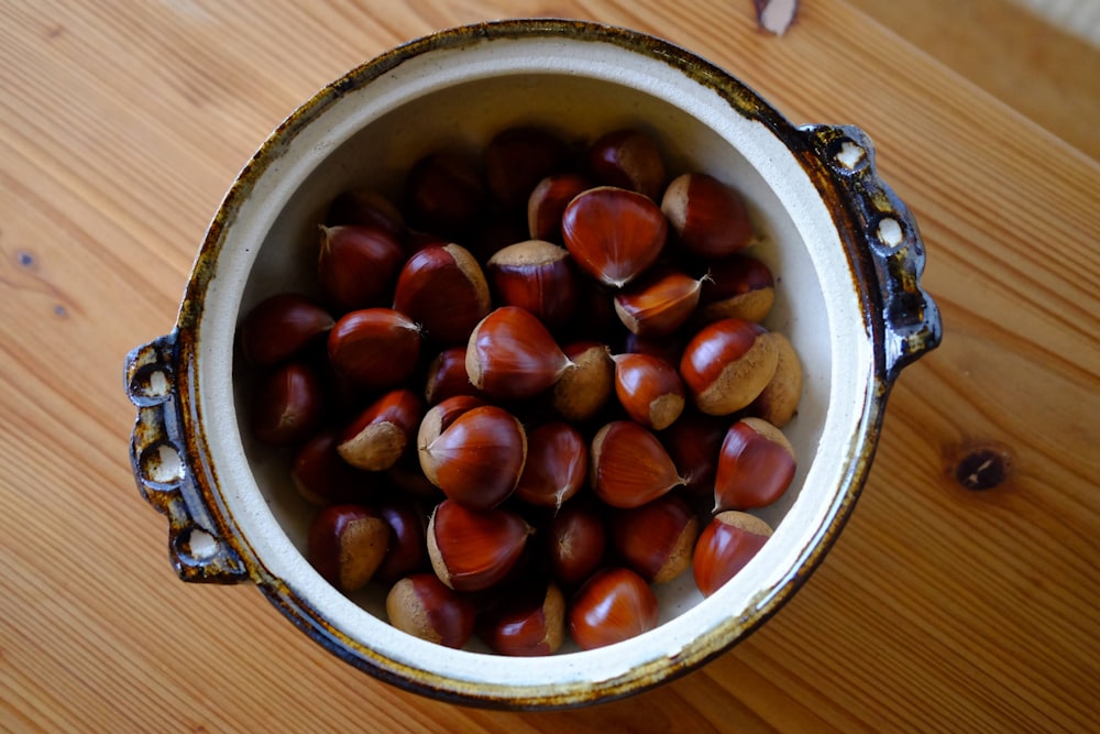 a bowl filled with nuts on top of a wooden table