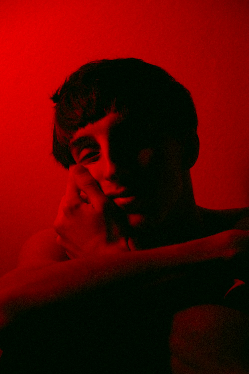 a man in a dark room with a red light