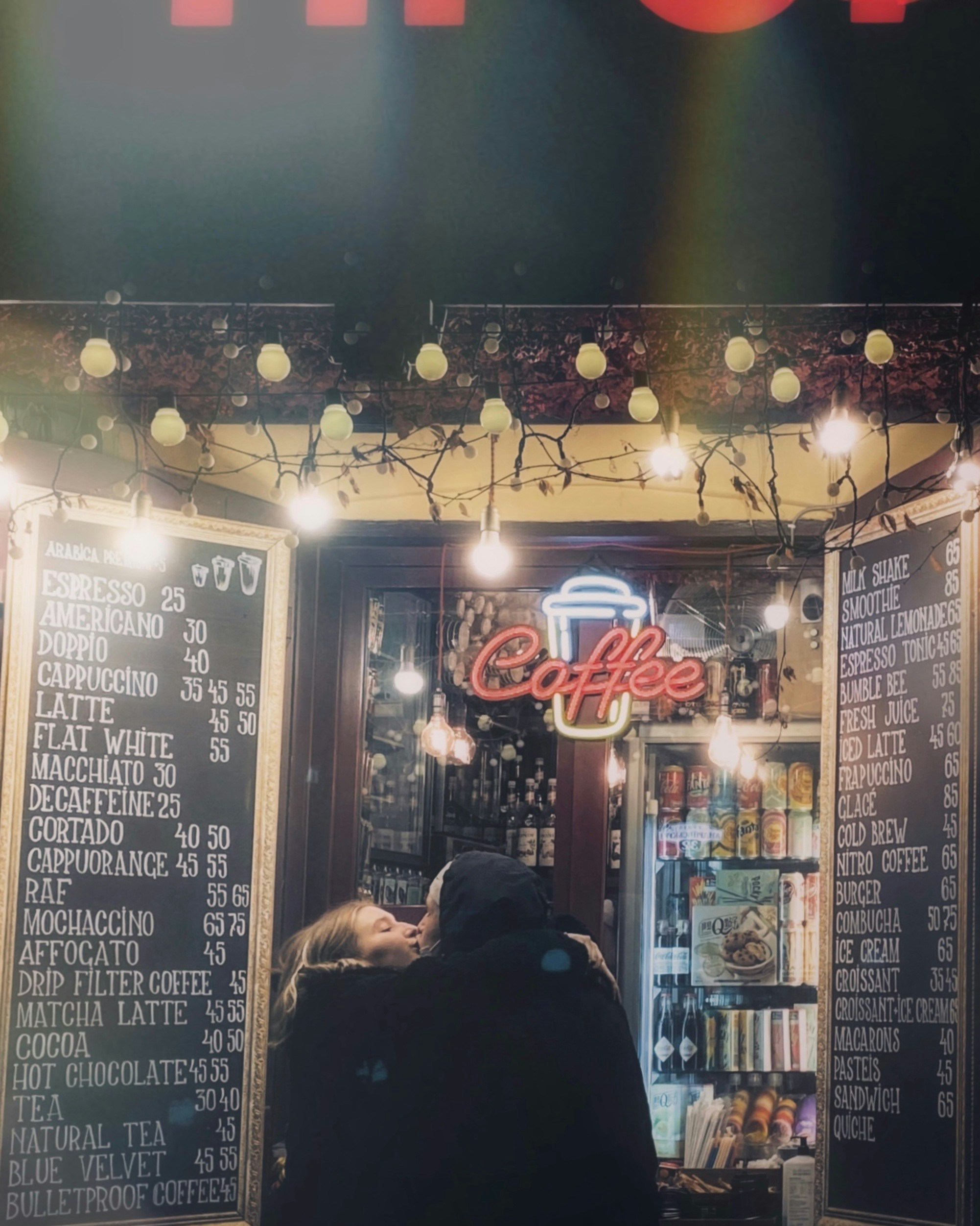 a person sitting in front of a coffee shop