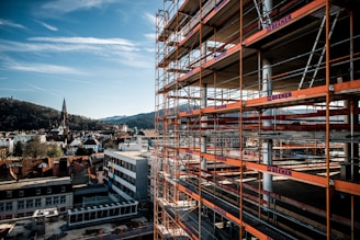 a building with scaffolding around it and a clock tower in the background