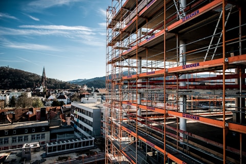 a building with scaffolding around it and a clock tower in the background