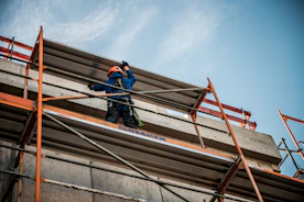a man on a scaffold working on a building