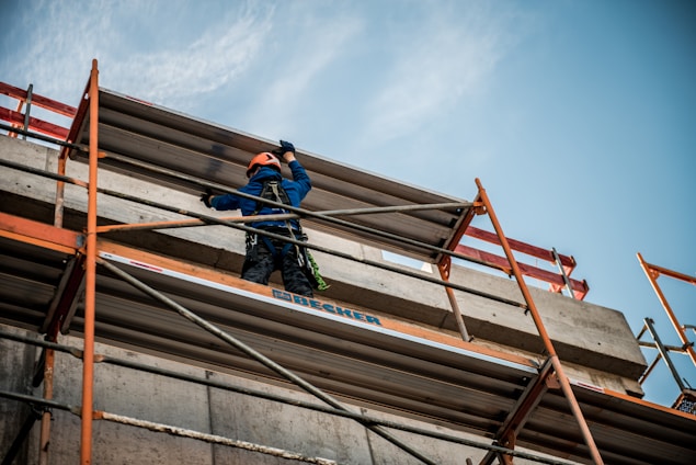 a man on a scaffold working on a building