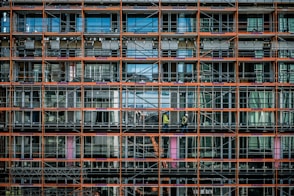 a man standing on a scaffolding in front of a building