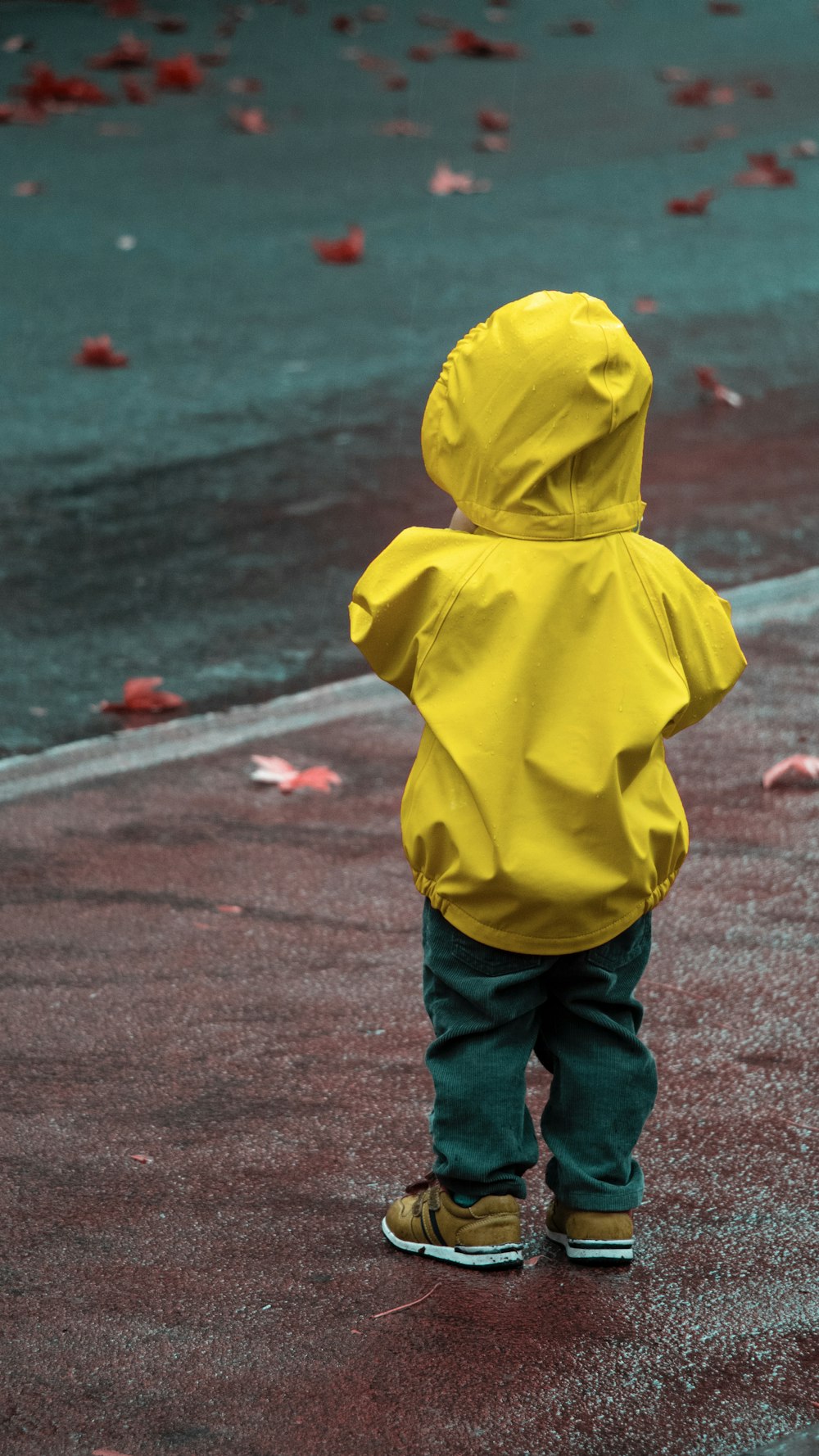 a small child in a yellow rain coat