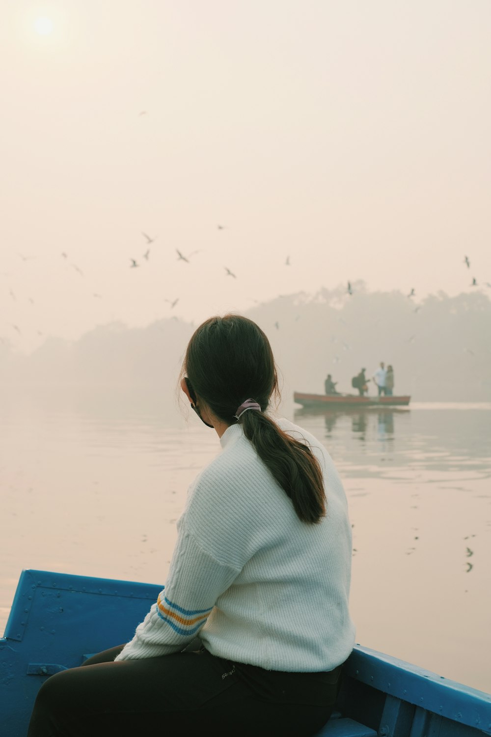 a woman sitting in a boat on a lake