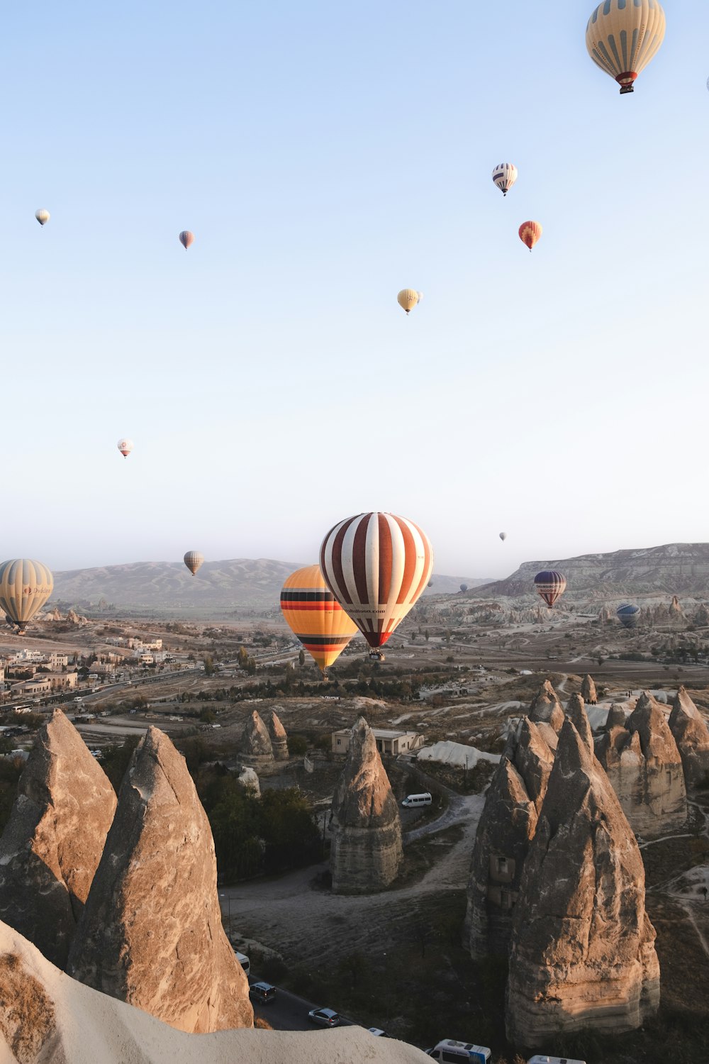 a group of hot air balloons flying over a valley