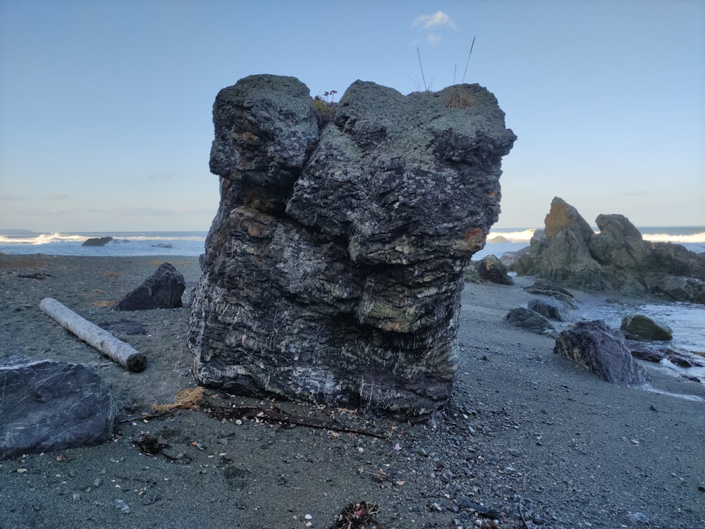 a large rock sitting on top of a sandy beach