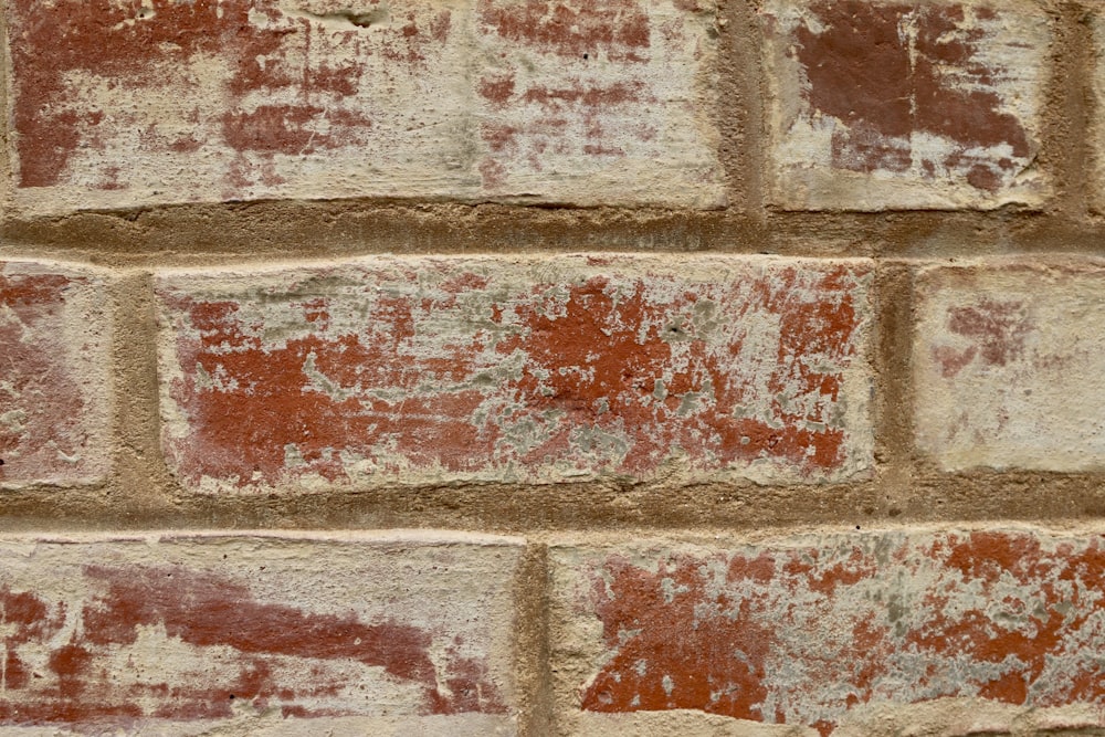 a close up of a brick wall with red and white paint