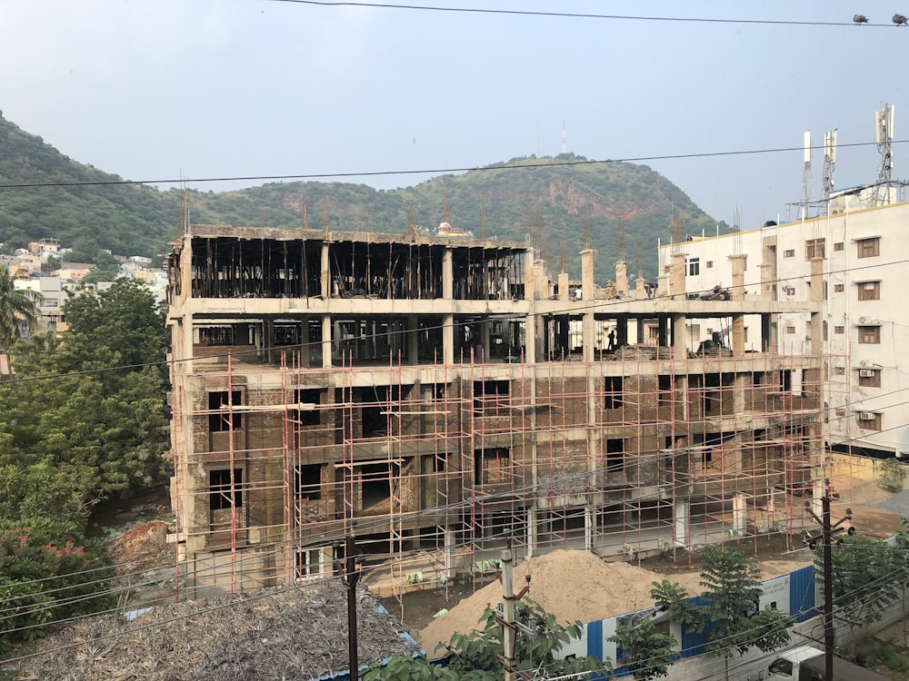 a building under construction with a mountain in the background