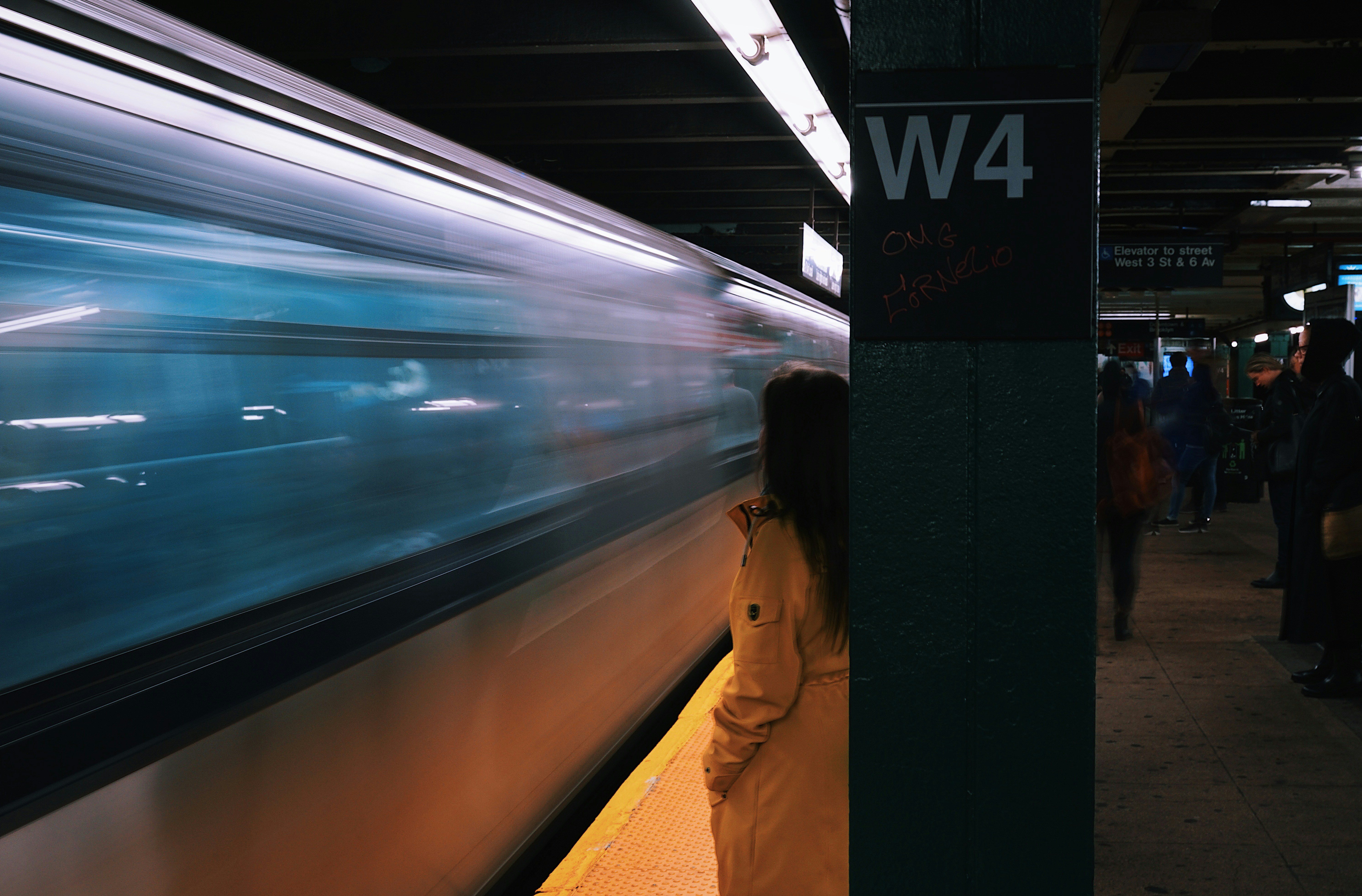 a woman standing next to a train at a train station