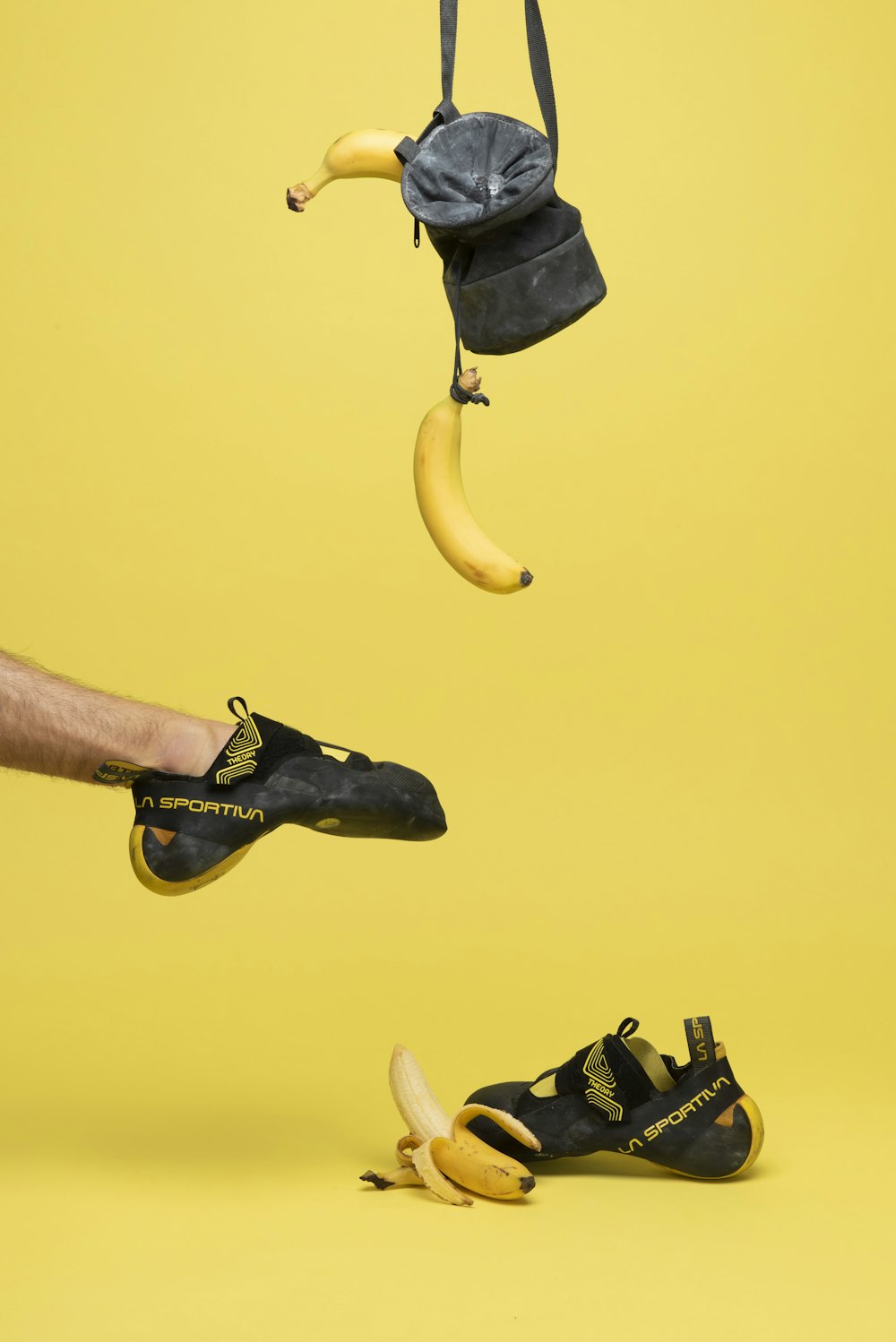 una banana appesa a una corda accanto a un paio di scarpe