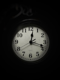 a black and white clock in the dark