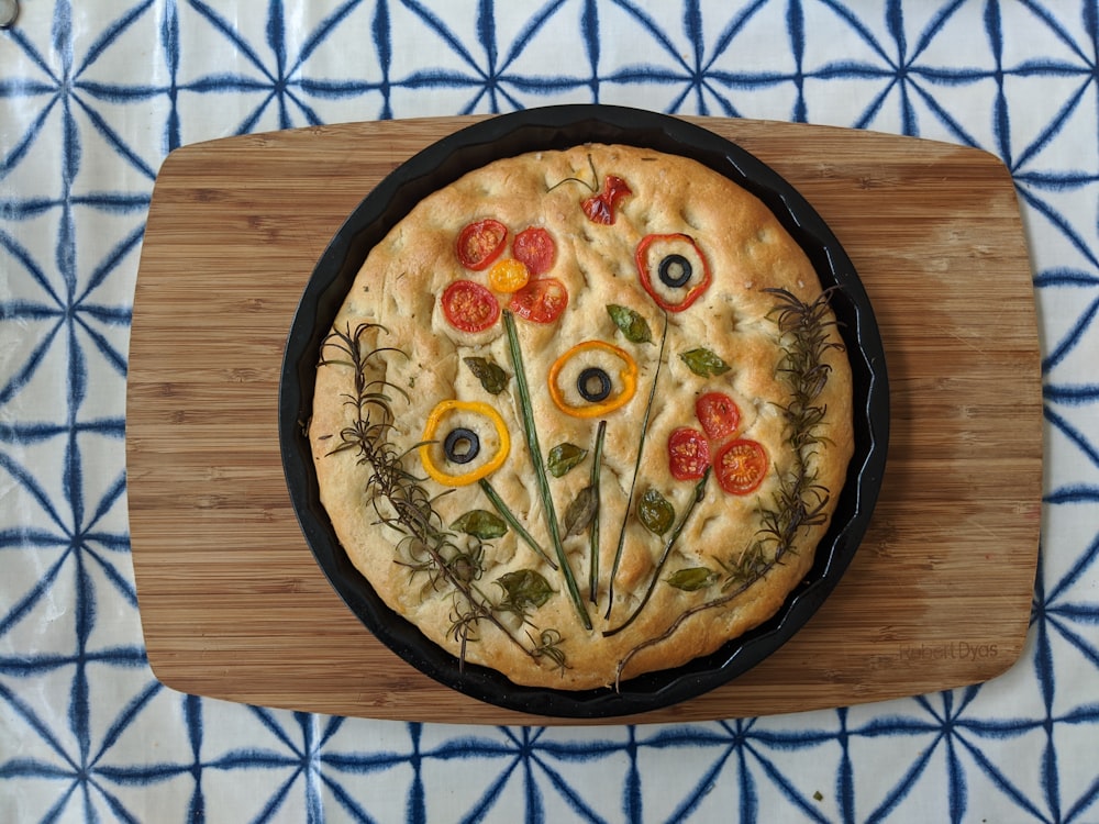 a pizza sitting on top of a wooden cutting board