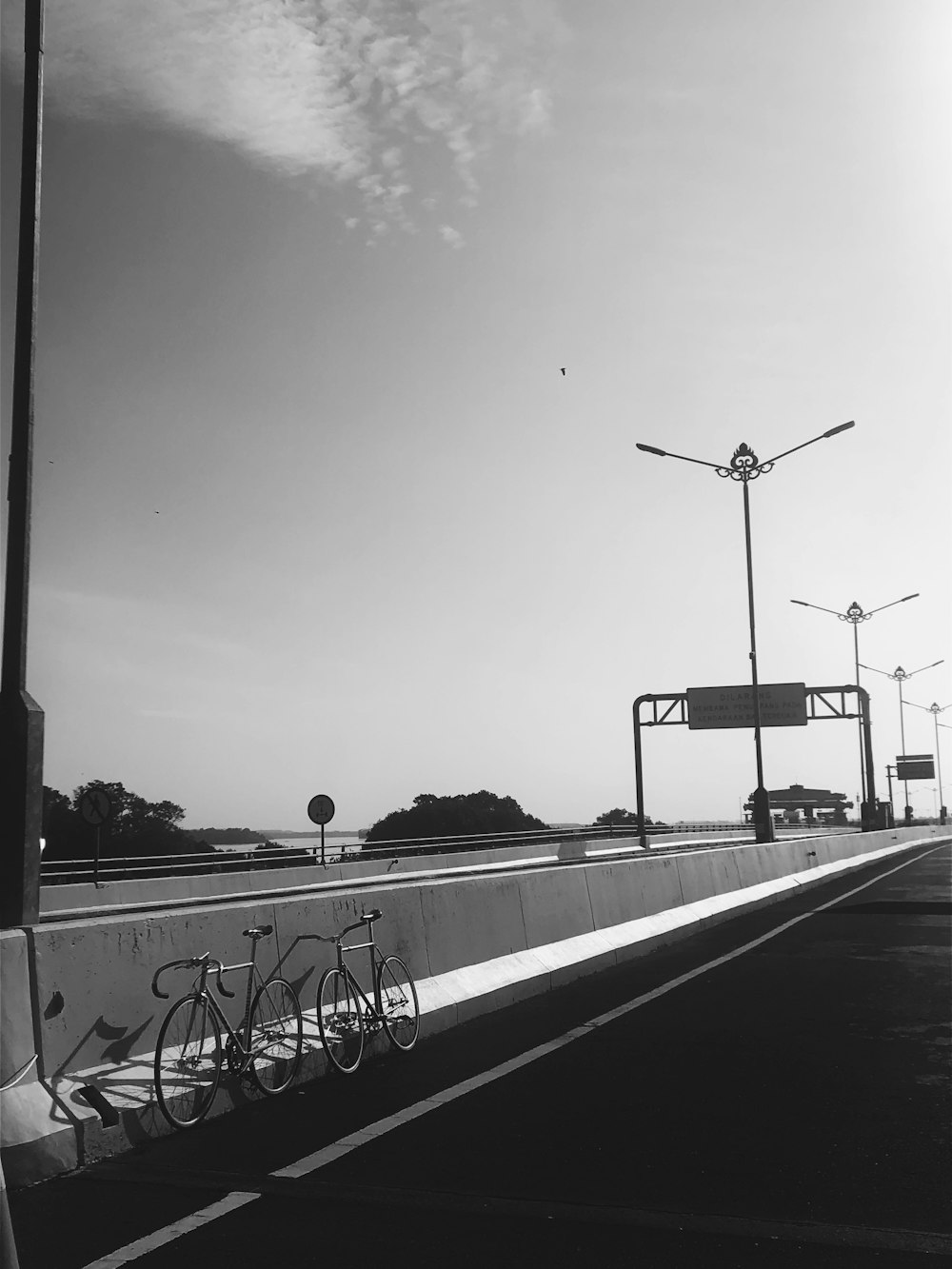 a black and white photo of a bike leaning against a wall