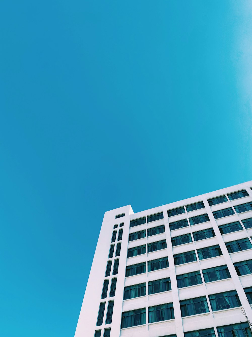 a tall white building with a blue sky in the background