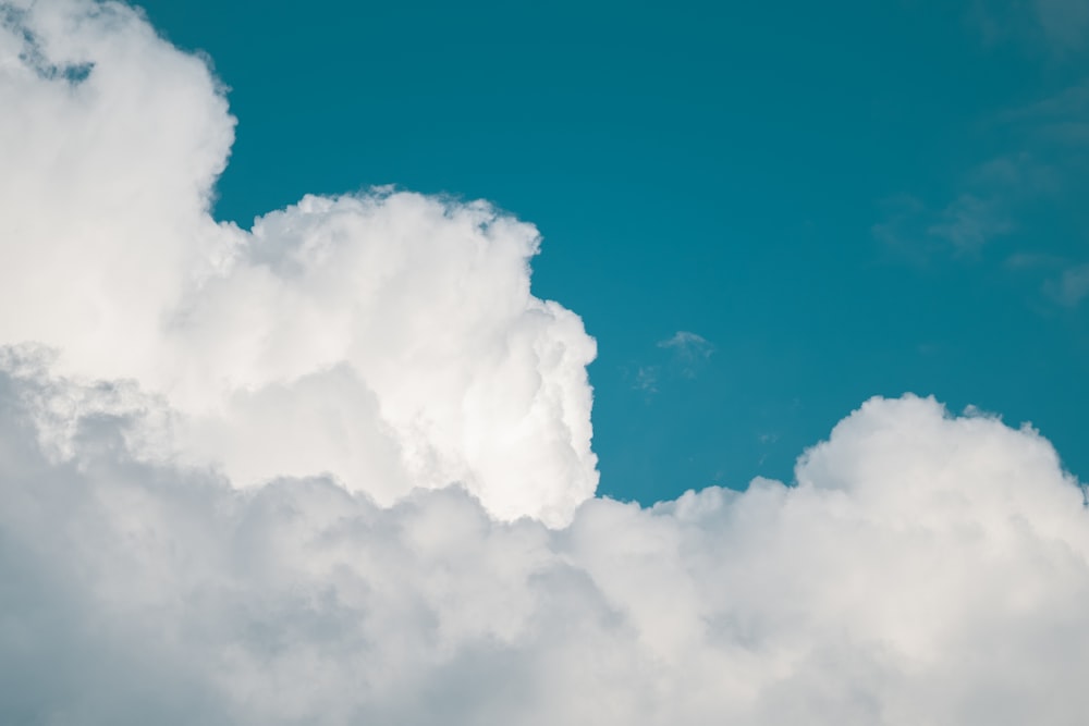 a plane flying through a cloud filled sky