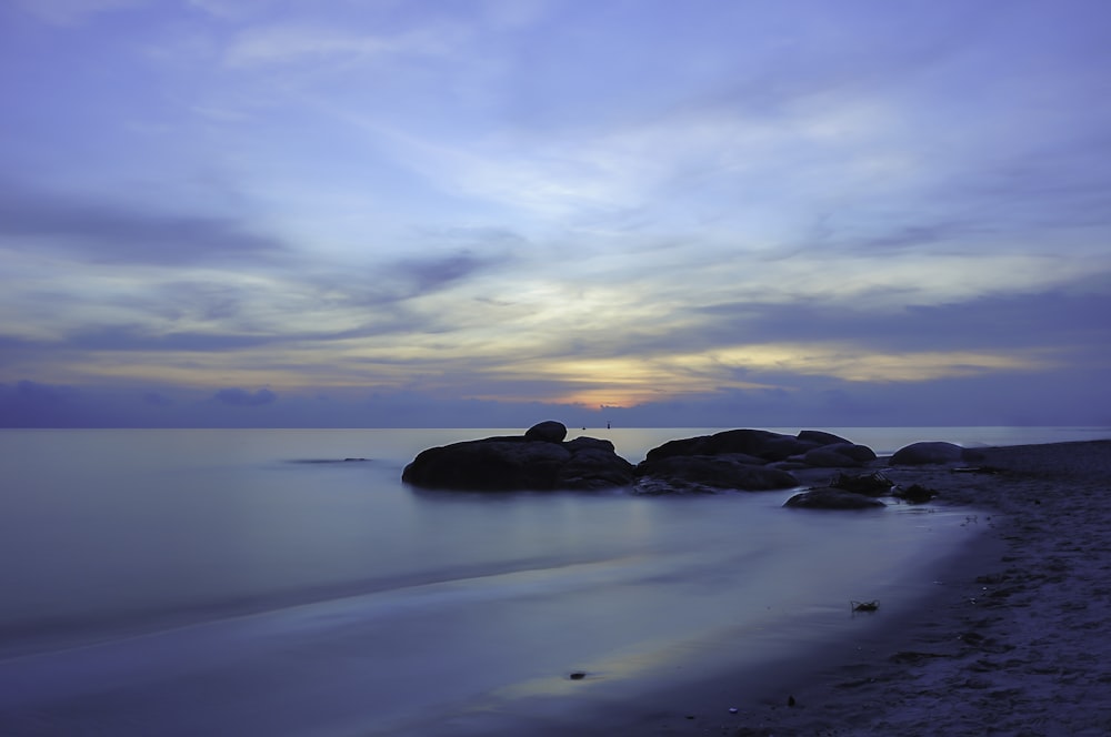 a couple of large rocks sitting on top of a beach