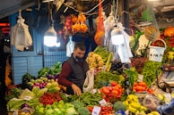 a man standing in front of a display of vegetables