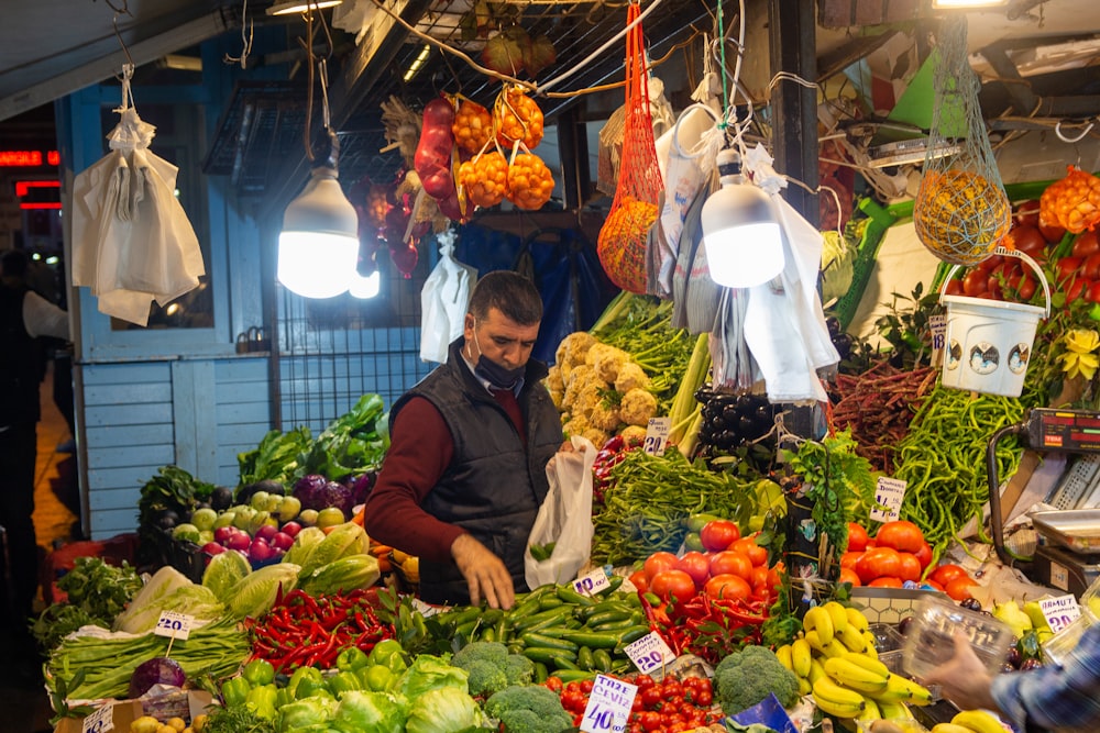 a man standing in front of a display of vegetables