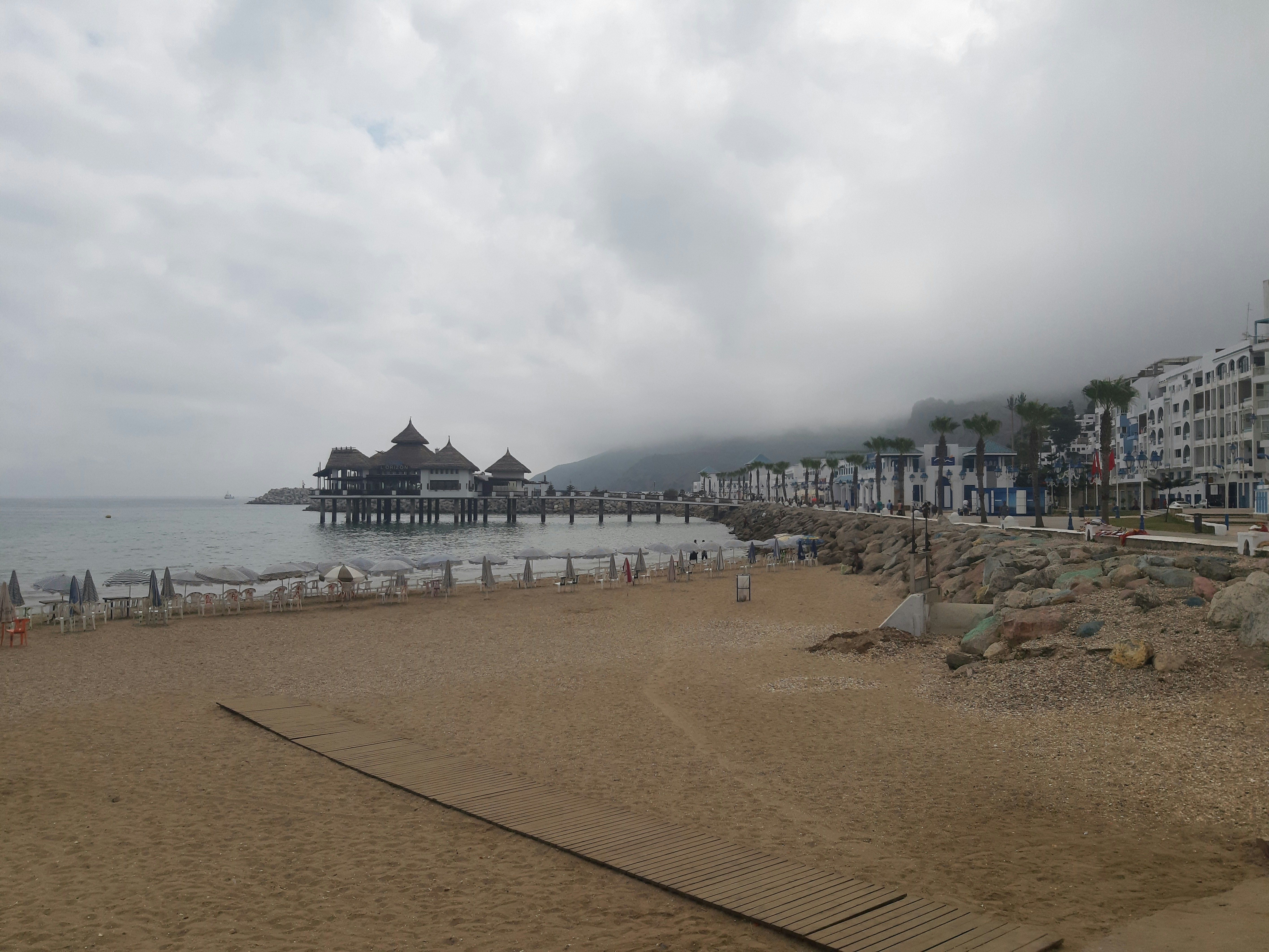 a sandy beach next to a body of water