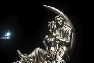 Luxurious gold-accented 3D wedding couple sculpture, set against a sleek black backdrop.