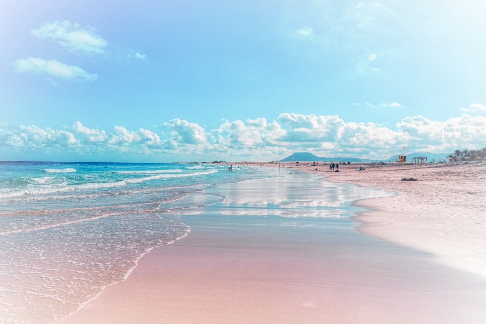 a sandy beach with waves coming in to the shore