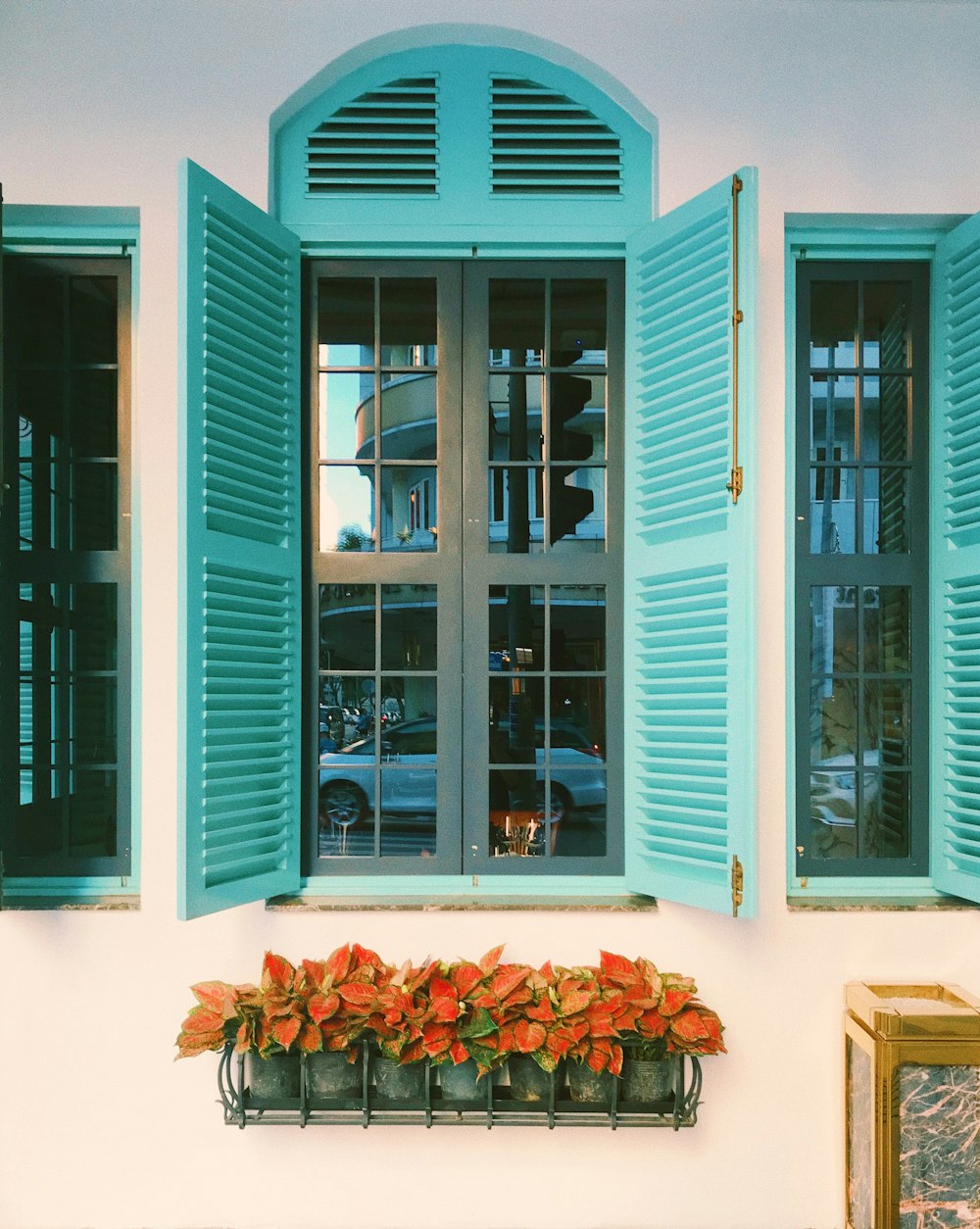 a window with blue shutters and a flower box