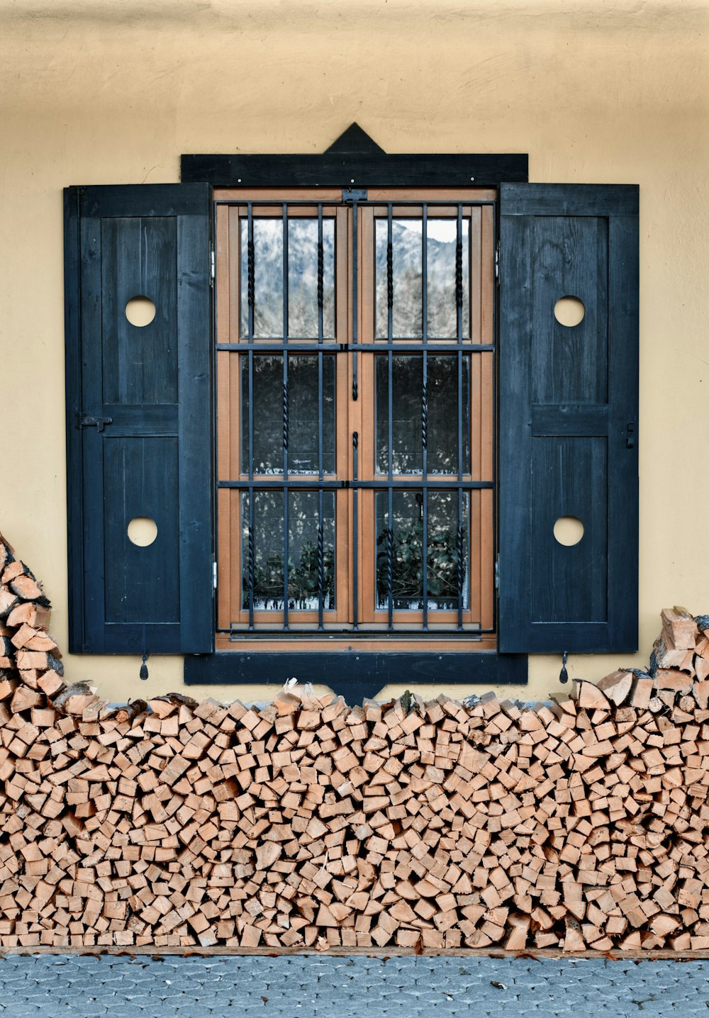 a stack of firewood sitting in front of a window