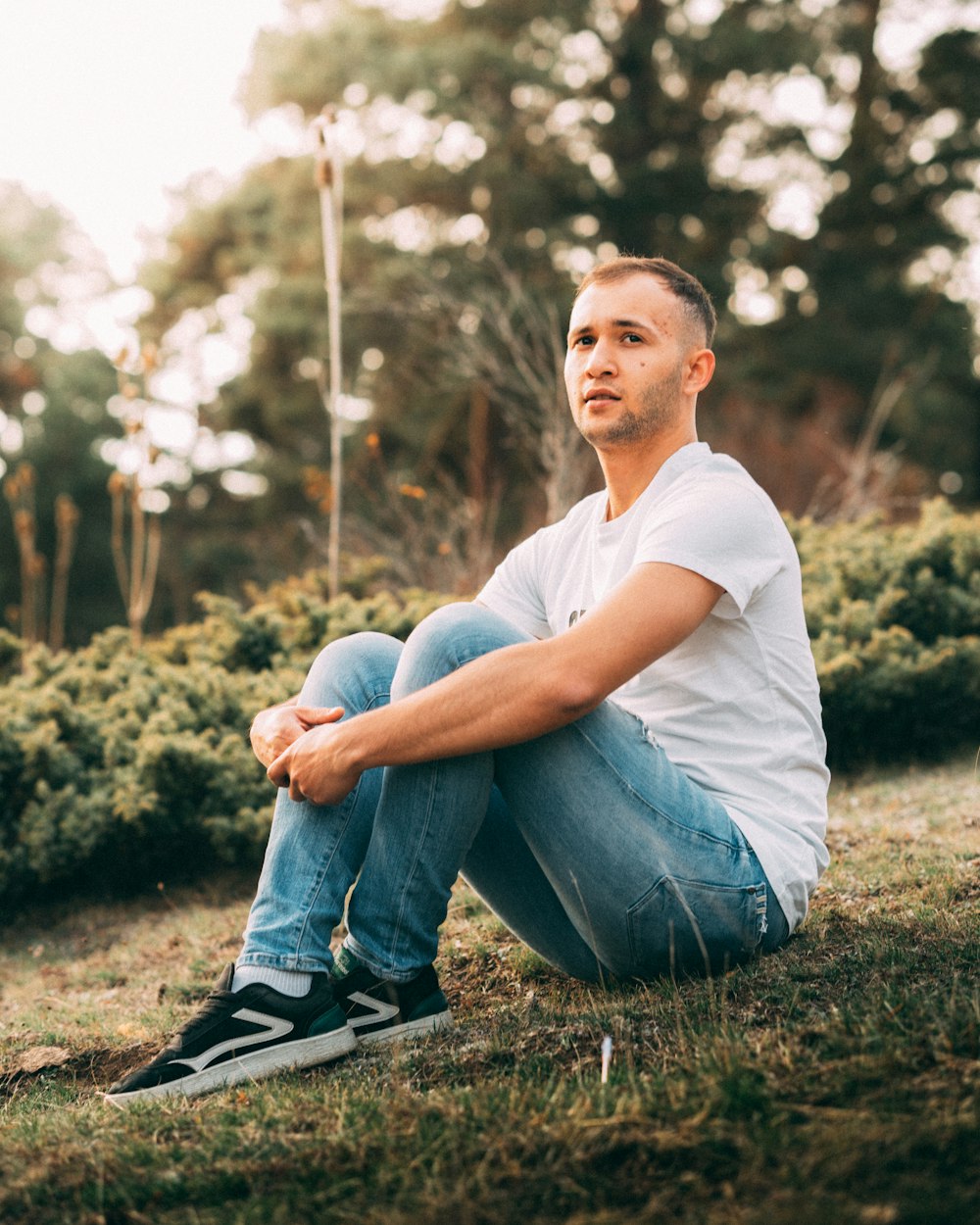 a man sitting on the ground in a field