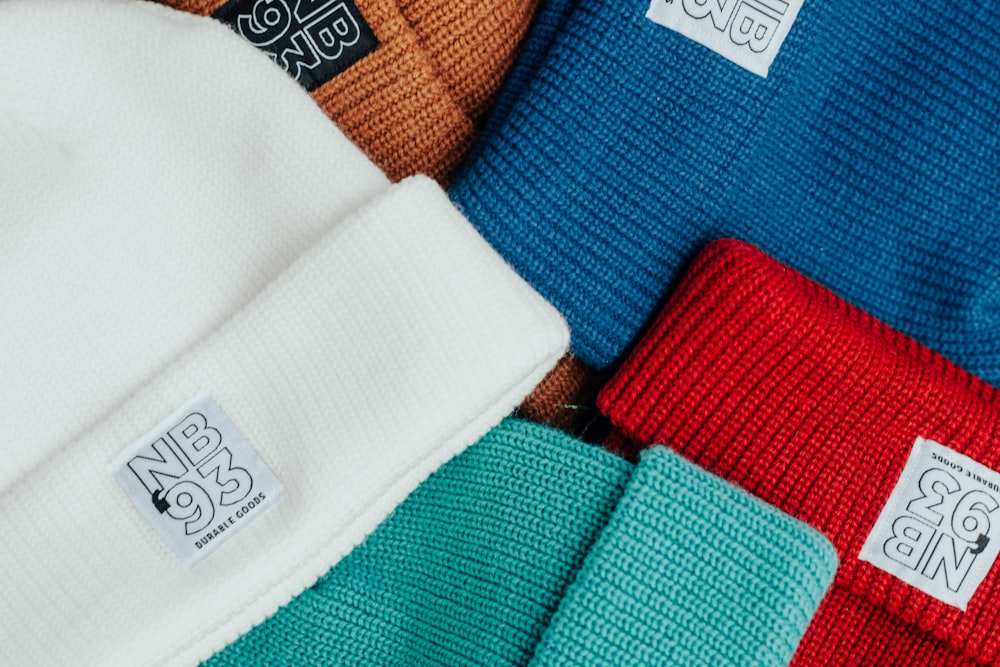 a pile of different colored beanies sitting on top of each other
