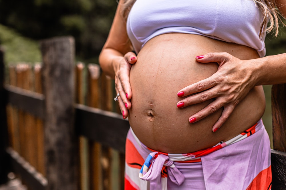 a pregnant woman with her hands on her stomach