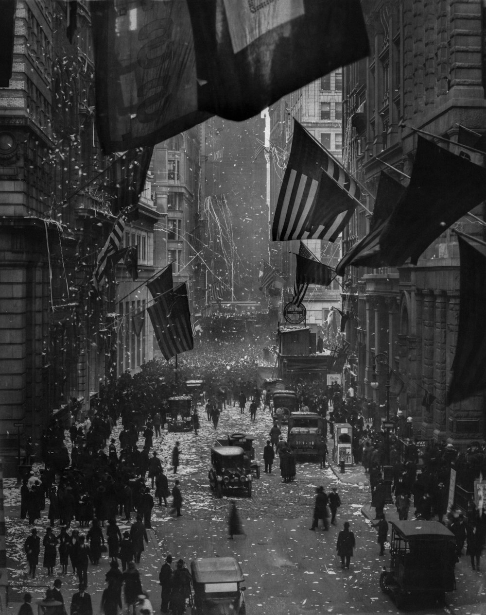 a crowd of people walking down a street next to tall buildings