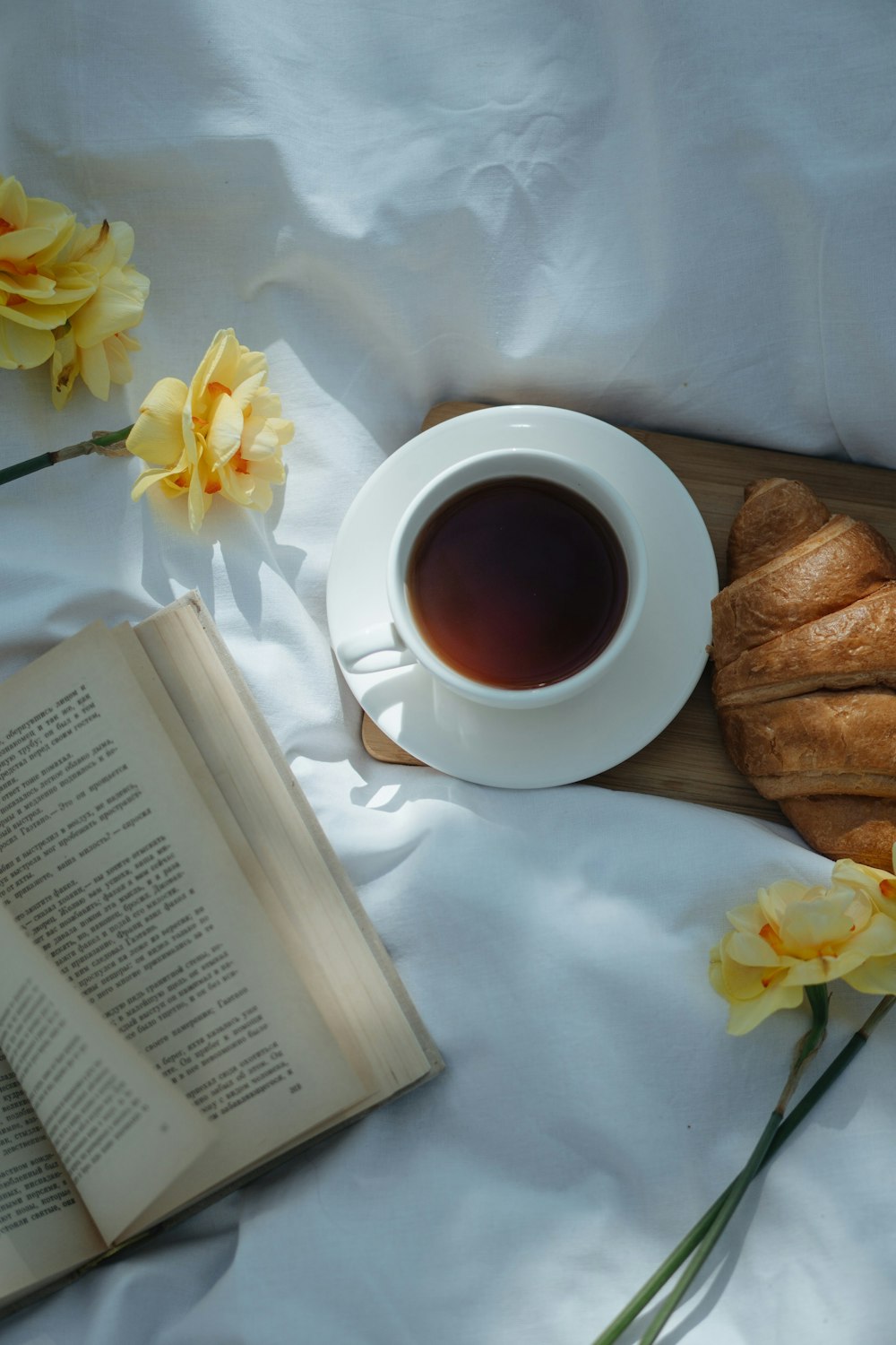a cup of tea and some croissants on a bed